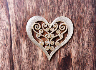 Christmas ornament in the shape of a heart on a dark wooden background. Top view. Close up. Copy space. 