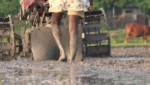 An Indian farmer uses a machine to plow a piece of land in a village in the Tamil Nadu province