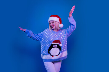 Photo of sweet cheerful lady santa helper dressed ugly print sweater having fun xmas event isolated blue color background
