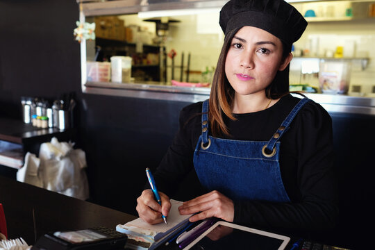 Multicultural Asian waitress taking order at Thai restaurant