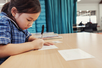 Young student girl writing in libary