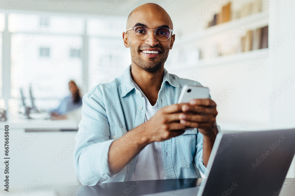 Poster business man using a smartphone while sitting with a laptop