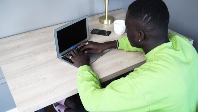 Young happy smiling afroamerican man working with modern laptop, technology and lifestyle young people concept