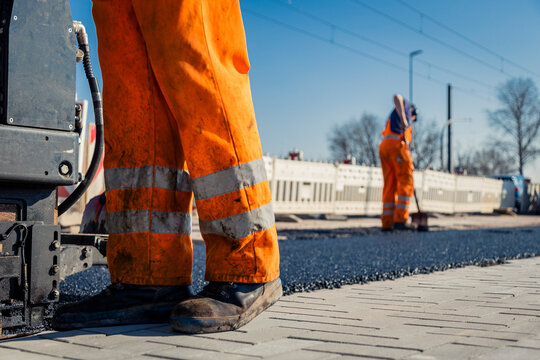 Stra&szlig;enbauarbeiter bei der Arbeit in der Sonne