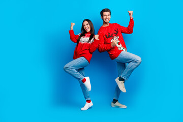 Full body photo of attractive young couple raise fists celebrate win dressed x-mas ornament red...