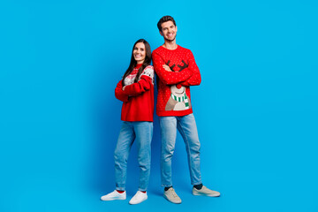 Full size photo of pretty young lovers crossed hands confident dressed x-mas ornament red sweaters isolated on blue color background