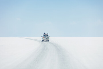 A car drives through the Salar de Uyuni salt lake, Bolivia