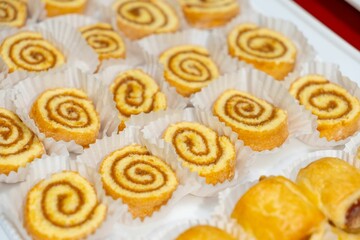 many different kinds of cookies on white trays next to a plate