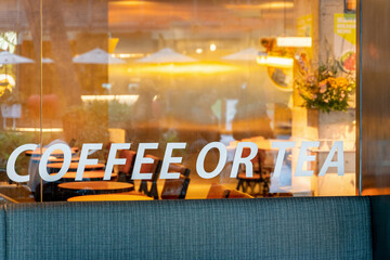 coffee or tea text printed on the window of modern drink shop.