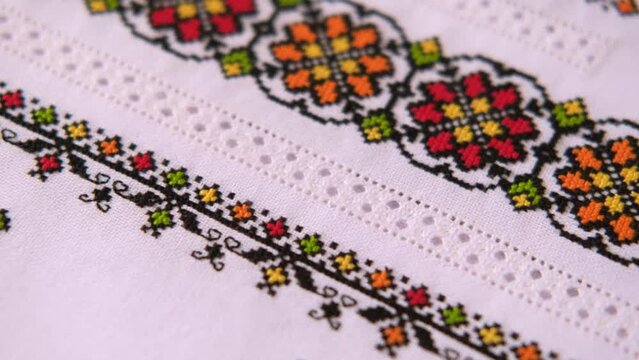 Linen white fabric with embroidered element. Ukrainian embroidery pattern.