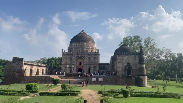 Tourists visiting the medieval monument of Bara Gumbad at Lodi Garden on a sunny day in Delhi, India