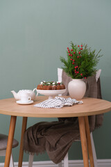 Christmas home interior-Christmas chocolate bundt cake with fresh berries and rosemary. Winter baking at Christmas or New Year with decorations. Ceramic vase with spruce branches.