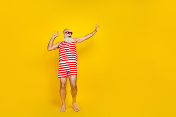 Full length photo of cool cheerful elderly guy dressed striped red swimsuit having disco fun empty...