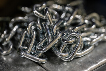 Stainless steel chain on a pile in a warehouse.