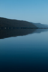 Beautiful view of a mountain and calm water with smooth surface.