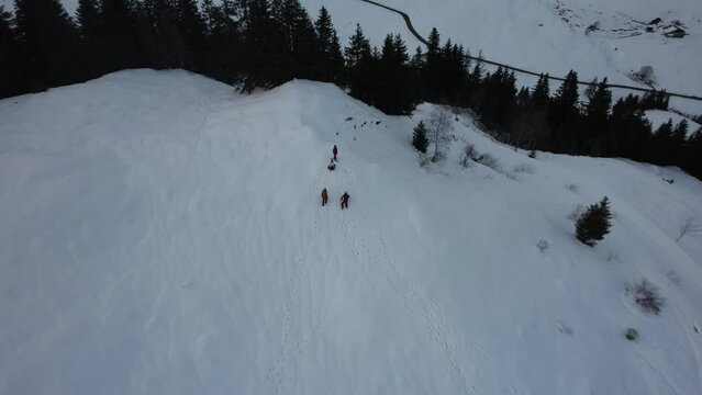 Drone view of people climbs the snowy hill