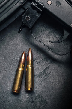 Bullets for Kalashnikov assault rifle on gray concrete background, top view. Cartridge 7.62 caliber for ak 47 closeup