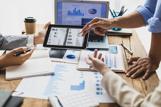 Business people discuss marketing growth chart and make business plan. Business meeting, financial consultants brainstorm analysis of statistical charts in financial reporting documents.