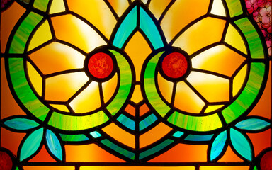 Small detail of a generic Art Nouveau style stained glass window. Yellow orange and red tones, with...