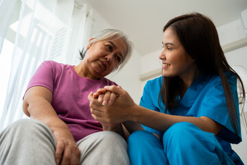 Fototapeta premium Caregiver for elderly talking with depression, dementia senior woman for protection melancholy trouble. Asian aging suffering from depression. Caregiver or nurse support happy retirement service.