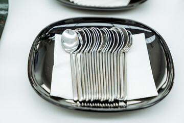 A set of teaspoons lying on a serving plate, metal kitchen appliances, a small spoon, breakfast at the hotel.