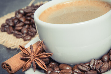 Coffee in cup and roasted dark coffee beans with anise and cinnamon