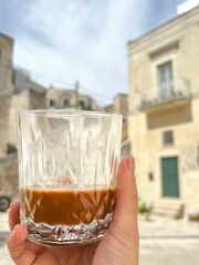 hand holds glass of local Leccese coffee in Lecce, Italy