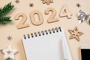 Fototapeta na wymiar New Year Aims 2024. To Do List. Empty Notebook at the Desk with Holiday Decoration. Top view. Creating Plan, Resolution. New Life, Start Up, Beginning Concept. Business ideas. Goals, action, checklist