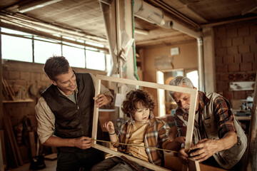 Three Generations of Carpenters : Grandfather, Father, and Son working in the Workshop