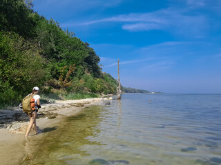 Woman tourist walk across wild coast of Baltic Sea. Puck Bay.