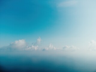Blue sky with white clouds over calm summer panorama of the sea. Drone aerial view. Abstract aerial...