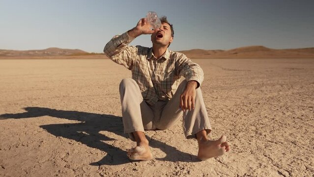 A man in the desert drinks his last water