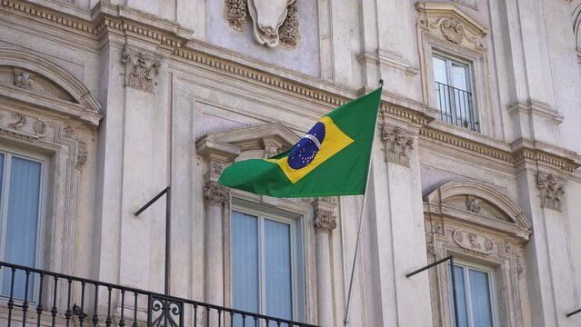 Closeup of Brazilian flag waving at embassy in Rome. Such building hosts consulate of Brazil. Flag of Brazil on flagpole flapping in wind, no people, nobody. Shooting in slow motion.