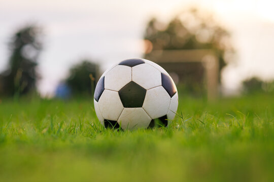 Close-up ball on green grass field for street soccer football sport game.