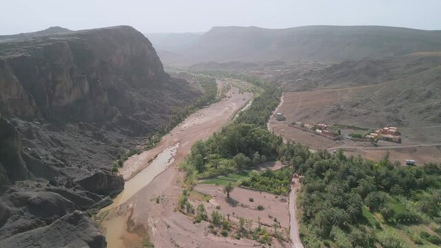 Aerial view of Oued Fint, High Atlas Mountains, Ouarzazate, Morocco. Slow lateral cinematic drone footage. Palm trees and village of Fint river. Popular tourist travel destination of Maghreb.