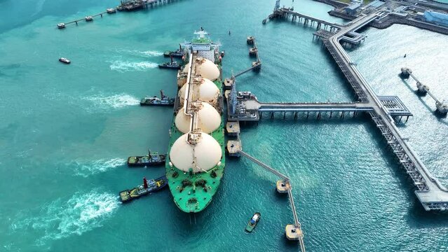 LNG (Liquefied natural gas) tanker anchored in Gas terminal gas tanks for storage. Oil Crude Gas Tanker Ship. LPG at Tanker Bay Petroleum Chemical or Methane freighter export import transportation 