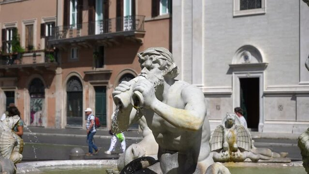 Detail sculpture of triton, greek God. Fontana del Moro, Moor Fountain located in Piazza Navona on sunny day. Moor standing in conch shell, wrestling with dolphin, surrounded by four Tritons.