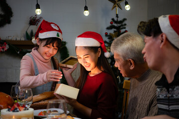 Happy Asian family celebrating Christmas at home. with the activity of giving gifts to each other among family members