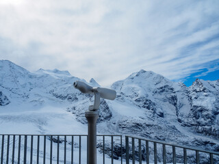 Medium shot of modern telescope at Diavolezza view point, for seeing closely the Bernina Range, one of famous travel destinations in Switzerland. Clearly see Piz Bernina at background.