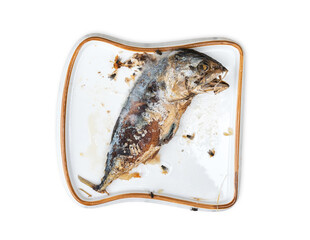 The food waste. Remains of fried fish. Fried mackerel that was forgotten on the table was spoiled and moldy and swarming with flies in a white plate the shape of bread isolated on white background.