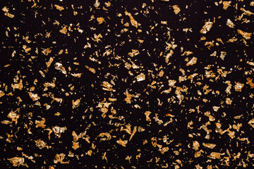 Golden glitter on black background. Shining golden shimmering background. Christmas, event, holiday concept