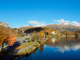 Naklejka premium Magnificent autumn atmosphere of St.Moritz, famous and luxury ski resort town, located in the upper Engadin valley in the south-eastern corner of Switzerland. See road and footpath alongside the lake.