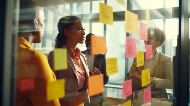 Business people meeting at office and use post it notes to share idea.Profession businesswomen,businessmen and office workers working in team conference Brainstorming concept.Sticky note on glass wall