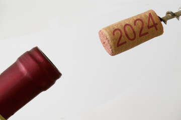 uncorked bottle of wine and cork with inscription 2024 - 667754690