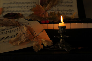 piano, notes and autumn fallen leaves  with candle light - 667754860
