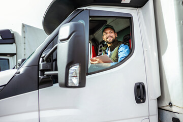 Young handsome man working in towing service and driving his truck.