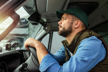 Young handsome man working in towing service and driving his truck.