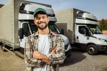 Happy confident male driver standing in front on his truck
