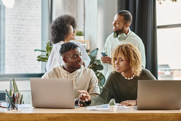 Fototapeta premium african american young friends in casual attires working together on their project, business concept