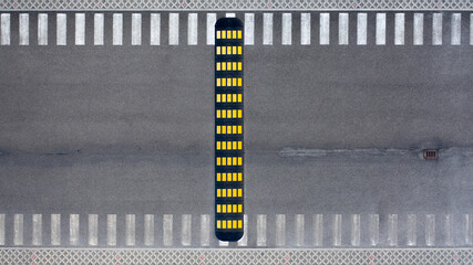 Aerial zenithal view of an empty road with an artificial speed bump.
